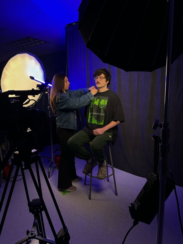 Student getting a mic placed on a video shoot