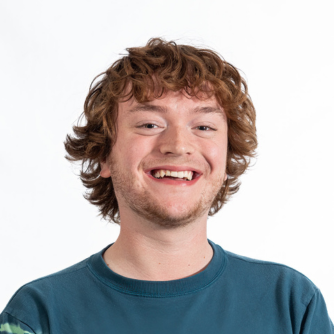Dylan posing for a professional headshot and smiling.