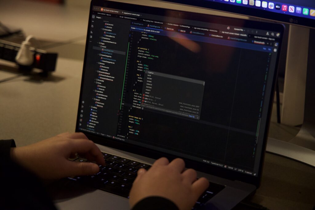 A developer typing out code onto a laptop